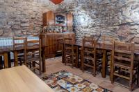 un restaurante con mesas y sillas de madera y una pared de piedra. en Albergue de peregrinos en CIRAUQUI - CASA MARALOTX Camino de Santiago, en Cirauqui