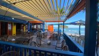 a balcony of a restaurant with tables and chairs and the ocean at Kaliman Pousada in Ubatuba