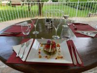 Una mesa con un plato de comida y copas de vino. en Logis Hôtels - Hôtel Restaurant Domaine Les Falaises, en Martel