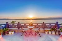 a table and chairs on a balcony with a view of the water at Blue Sea Hotel in Dali