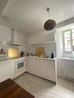 a white kitchen with white cabinets and a window at Lou Mut in Lectoure