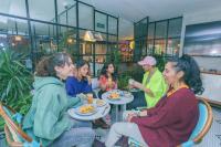 um grupo de pessoas sentadas ao redor de uma mesa comendo comida em Viajero Bogotá Hostel & Spa em Bogotá