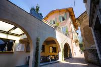 an alleyway in a building with arches and a building at Locanda Alberti in Mandello del Lario