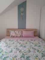 a bed with a floral bedspread and two pillows at Apartment Ken in Surčin