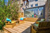 a wooden deck with benches and pillows on a building at Le Pop in Saint-Julien-Chapteuil