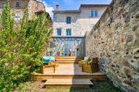 a house with a stone wall and a wooden deck at Le Pop in Saint-Julien-Chapteuil