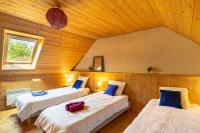 a room with three beds in a wooden cabin at Ty Lann in Telgruc-sur-Mer