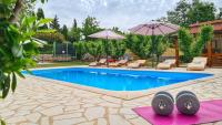 a swimming pool with chairs and umbrellas next to a pool at Villa Prima Natura, Imotski private pool in Imotski