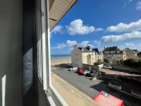 a view from a window of the beach and buildings at Le Clos Normand in Saint-Aubin-sur-Mer