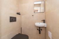 a bathroom with a sink and a toilet and a mirror at Ivka Makarska - modern and luxurious oldtown apartament in Makarska