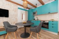a kitchen with blue cabinets and a table and chairs at Ivka Makarska - modern and luxurious oldtown apartament in Makarska
