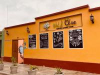 un edificio amarillo con carteles a un lado. en Wild Olive Guest House, en Ica
