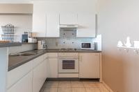 a kitchen with white cabinets and a microwave at Appartement Blankenberge Zeedijk aan de Pier in Blankenberge