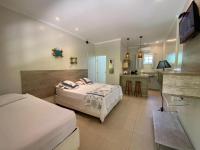 Una habitación de hotel con dos camas y cocina. en Suites Prime Itamambuca, en Ubatuba