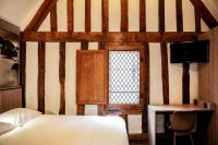 a bedroom with a bed and a desk and a window at Le Mouton Blanc in Le Mont Saint Michel