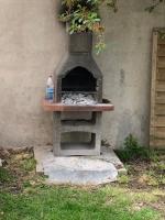 an outdoor oven with a bottle of water on it at Villa Tenjin chambre 16 in Bondy