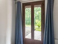 a wooden door with blue curtains in a room at Holiday Home with Roofed Swimming Pool in Villeneuve-sur-Lot
