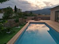 a swimming pool in a backyard with a wooden deck at Villa T4 avec piscine in Lucciana