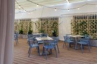 um restaurante com mesas e cadeiras azuis sobre um piso de madeira em Hotel Costa Málaga - Adults Recommended - by Pierre & Vacances em Torremolinos