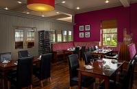 a dining room with tables and chairs and purple walls at Great National Hotel Ballina in Ballina