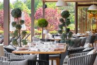 a dining room with tables and chairs and flowers at Viva Mare Beach Hotel by Santa Marina in Sozopol