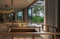 uma sala de jantar com mesas e uma grande janela em Noku Phuket em Chalong