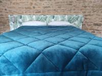 a blue comforter on a bed in a bedroom at Appartement Oingt - Les Meublés des Pierres Dorées in Theizé