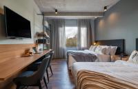 a hotel room with two beds and a flat screen tv at Jangal das Araucárias Swan Design Hotel Canela in Canela