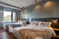two beds in a hotel room with a large window at Jangal das Araucárias Swan Design Hotel Canela in Canela