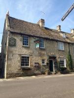 un antiguo edificio de piedra al lado de la calle en The Royal Oak Burford, en Burford