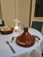 a table with a brown pot on a white table cloth at Hotel Delphin-Nouadhibou in Nouadhibou