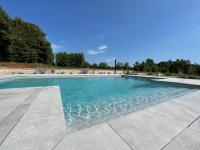 a swimming pool with blue water at VILLA BERTO in Nedeščina