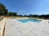 a swimming pool with a stone floor and a patio at VILLA BERTO in Nedeščina