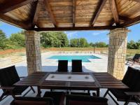 a patio with a table and chairs and a swimming pool at VILLA BERTO in Nedeščina