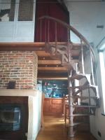 a spiral staircase in a room with a fireplace at Villa Blanco in Opwijk
