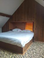 a bedroom with a large bed with wooden walls at Villa Blanco in Opwijk