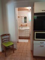 a kitchen with a microwave and a chair in it at Gîte 2 personnes, proche mer in Challans
