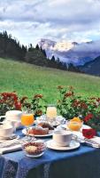 una mesa con comida y vistas a la montaña en Hotel Miramonti Corvara, en Corvara in Badia