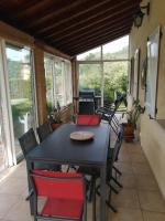 a black table and chairs on a screened in porch at Villa de vacances avec piscine chauffée proche d Anduze in La Barriére