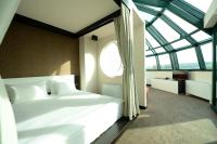 a bedroom with a large white bed and a window at Hotel Hedonic in Belgrade