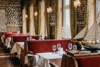 a restaurant with white tables and wine glasses at Hotel Alter Muschelsaal in Büsum