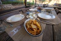 a wooden table with a plate of food and french fries at vita campıng otel in Geyikbayırı