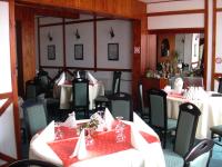 uma sala de jantar com mesas e cadeiras com toalha de mesa vermelha em Hotel Premier em Predeal