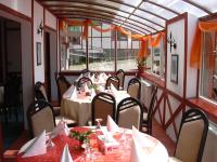 uma sala de jantar com mesas e cadeiras em um restaurante em Hotel Premier em Predeal