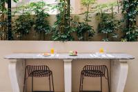 a table with two chairs and a counter with plants at Athinais Hotel in Athens