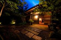 una casa con una pasarela de piedra delante por la noche en Yufuin Gettouan, en Yufu
