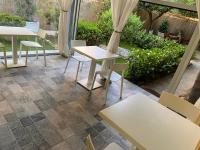 a patio with tables and chairs and a garden at PARADISE INN in Livorno