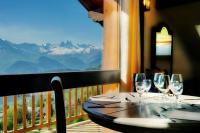 Una mesa con copas de vino en un balcón con montañas. en Lodge La Tuvière, en Jarrier