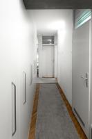 a corridor with white walls and a hallway with doors at Superbia Osijek - SELF CHECK-IN in Osijek