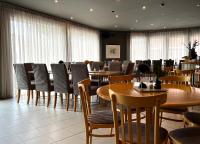 Un comedor con mesas y sillas y ventanas. en Sunderby folkhögskola Hotell & Konferens, en Luleå